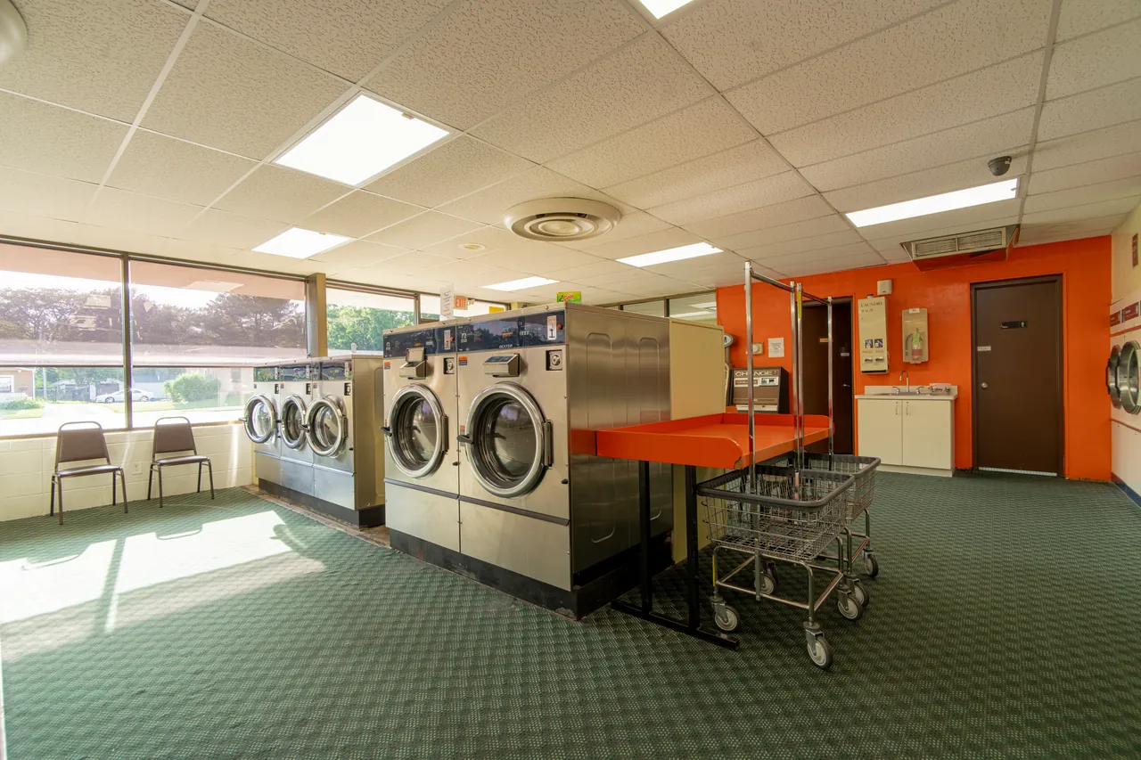 Washers, dryers, folding tables, and carts in the laundromat