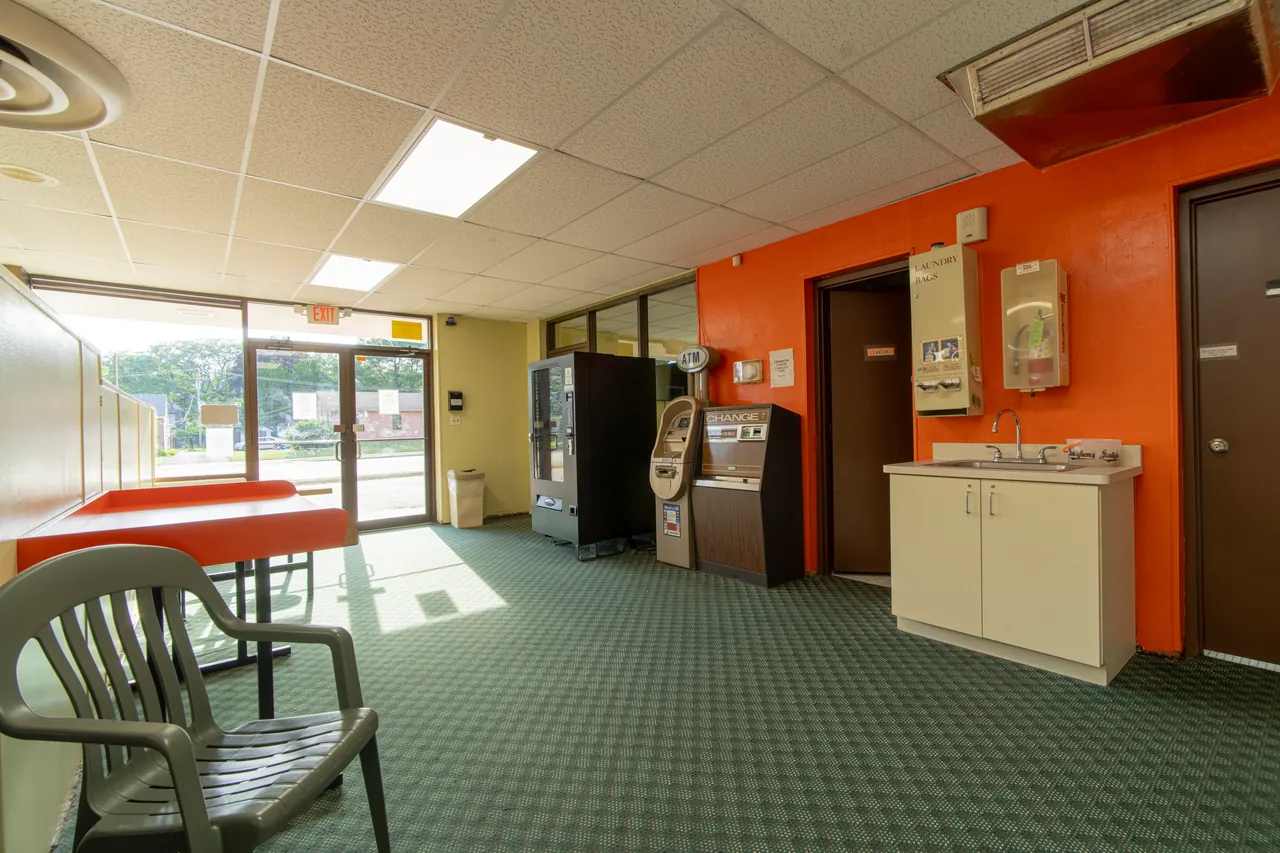 Seating and orange folding tables near the laundromat entrance